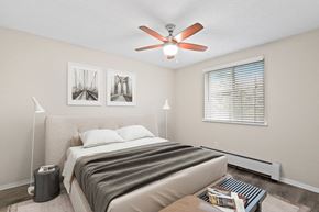 Denver apartment for rent - Relax in a light-filled bedroom with neutral tones, cozy textures, and a modern ceiling fan at 1303 Columbine in Denver, CO