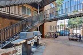 Denver apartment for rent - A black metal staircase with a glass balustrade leads to a balcony at 23–33 Pearl St in Denver, CO
