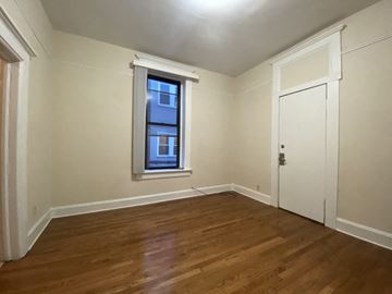 Chicago apartment for rent - A room with a wooden floor and a window.