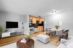 Denver apartment for rent - A modern living room with a wooden floor and white walls at 23–33 Pearl St in Denver, CO