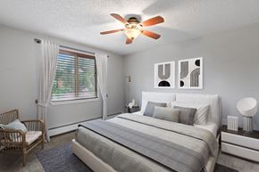 Denver apartment for rent - A bedroom with a bed, nightstand, and chair at 23–33 Pearl St in Denver, CO