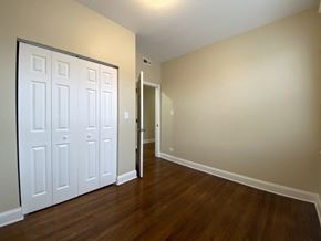 Chicago apartment for rent - A white door is in a room with wood floors and white walls.