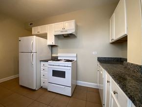 Chicago apartment for rent - A kitchen with white appliances and granite countertops.