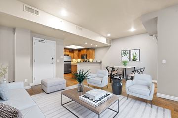 Denver apartment for rent - a living room with white furniture and a kitchen in the background