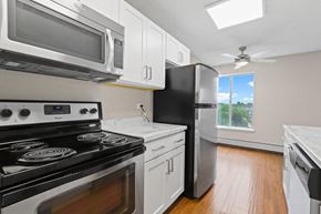 Denver apartment for rent - A kitchen with black appliances and white cabinets  at 4805 E Kentucky in Denver, CO