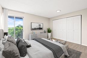Denver apartment for rent - A bedroom with a large bed and a painting of a bridge on the wall  at 4805 E Kentucky in Denver, CO