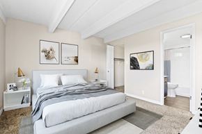 Denver apartment for rent - A bedroom with a large bed and two framed pictures on the wall.