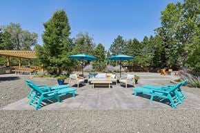 Centennial apartment for rent - A sunny day at a picnic area with blue benches and umbrellas.
