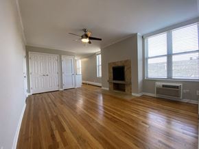Chicago apartment for rent - Living room with a ceiling fan and a fireplace - One Bedroom