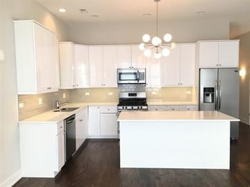 Chicago apartment for rent - A modern kitchen with white cabinets and a central island.