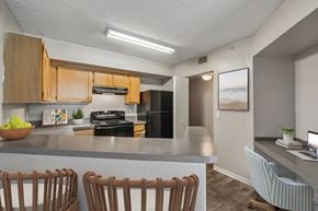 Jacksonville apartment for rent - A kitchen with wooden cabinets and a grey countertop.