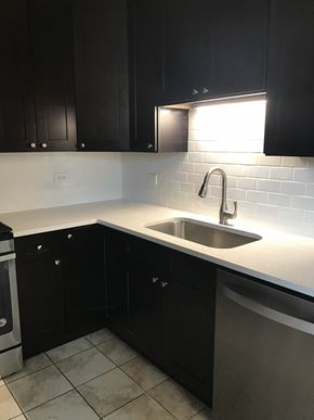 Chicago apartment for rent - Kitchen with rich wood cabinetry and subway tiled backsplash