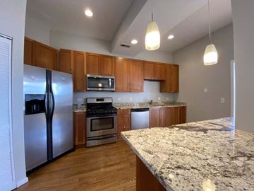 Chicago apartment for rent - A kitchen with a granite counter top and wooden cabinets.