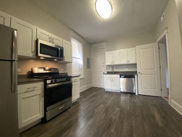 Chicago apartment for rent - A kitchen with white cabinets and a black stove top oven.