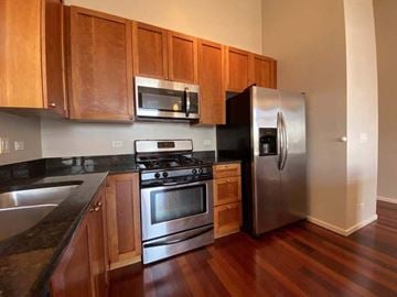 Chicago apartment for rent - a kitchen with stainless steel appliances and wooden cabinets