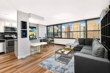 Chicago apartment for rent - A modern living room with a grey couch and a coffee table.