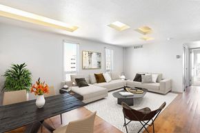 Denver apartment for rent - A modern living room with a black table and a white sofa.