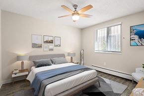 Denver apartment for rent - Bright bedroom with large window, ceiling fan, queen bed, and modern decor on light walls at 1443 Elizabeth in Denver, CO