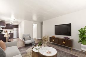Denver apartment for rent - A living room with a grey couch, a white coffee table, and a television on the wall at 1444 Saint Paul St in Denver, CO