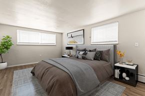 Denver apartment for rent - A bedroom with a large bed and a potted plant at 1444 Saint Paul St in Denver, CO