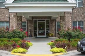 Virginia Beach apartment for rent - A building entrance with a brick wall and a yellow walkway.