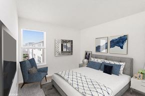 Newport News apartment for rent - A bedroom with a large bed and a blue chair.