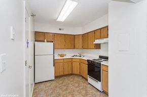 Newport News apartment for rent - A kitchen with wooden cabinets and a white refrigerator.