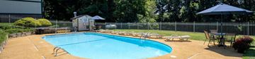 Akron apartment for rent - A small pool surrounded by a fence and chairs.