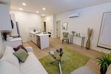 Calgary apartment for rent - A modern living room with a white couch and a glass coffee table.