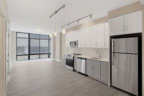 Rockville apartment for rent - A modern kitchen with white cabinets and a wooden floor.