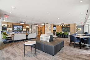 Rockville apartment for rent - A modern lounge area with a variety of seating options and a bar area.