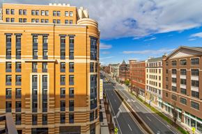 Rockville apartment for rent - A large building with a curved corner is in the middle of a street.
