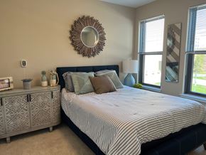 Rockville apartment for rent - A bedroom with a bed, nightstand, and a mirror on the wall.