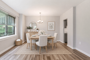Bethesda apartment for rent - A dining room with a round mirror, a chandelier, and a framed picture on the wall.