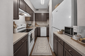 Bethesda apartment for rent - A kitchen with brown cabinets and a white refrigerator.