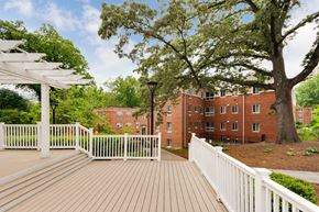 Silver Spring apartment for rent - A white fence surrounds a wooden deck with a white pergola over it.