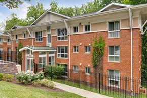 Silver Spring apartment for rent - A red brick apartment building with a black fence in front.