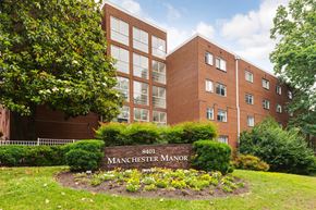 Silver Spring apartment for rent - A brick building with the number 8401 and the words Manchester Manor on a sign in front of it.