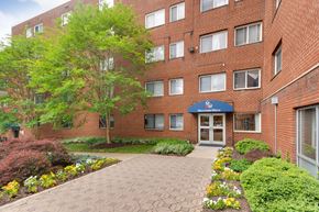 Silver Spring apartment for rent - A brick building with a blue awning and a garden in front.