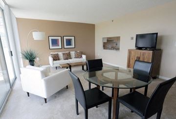 Bethesda apartment for rent - A living room with a glass table and white couch.