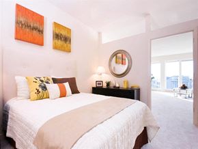 Wheaton apartment for rent - A bedroom with a large bed and two paintings on the wall.