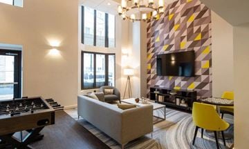 Silver Spring apartment for rent - A modern living room with a yellow chair and a grey sofa.