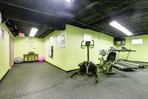 Silver Spring townhouse for rent - A gym with a green wall and a row of treadmills.