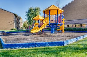 Derwood townhouse for rent - A playground with a yellow slide and blue platform.