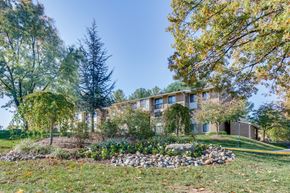 Derwood townhouse for rent - A large building with a landscaped front yard.