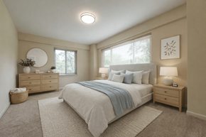 Bethesda townhouse for rent - A bedroom with a bed, nightstands, and a round mirror on the wall.