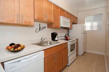 Silver Spring apartment for rent - A kitchen with wooden cabinets and white appliances.