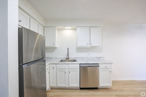 Bedford Heights apartment for rent - A kitchen with white cabinets and a stainless steel refrigerator.