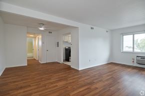 Bedford Heights apartment for rent - A large empty room with wood flooring and a window.