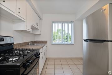 Bedford Heights apartment for rent - A kitchen with a black stove top and a stainless steel refrigerator.
